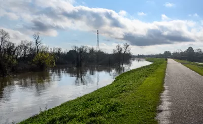 Paved bike path on top of earthen dike levee along Mississippi River in Louisiana.