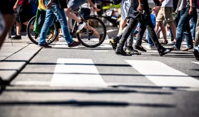 Low angle view of busy crosswalk with pedestrians and a bike.