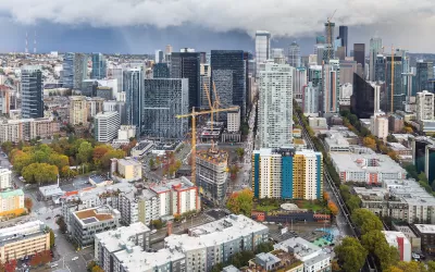 View of downtown Seattle with construction cranes and cloudy sky as seen from top of Space Needle.