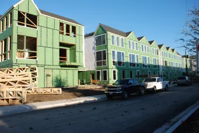 Three-story wood-frame apartment buildings under construction 