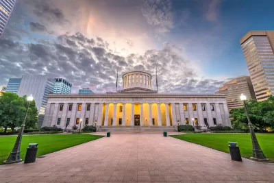 Ohio state capitol dome against dramatic lightly cloudy sky.