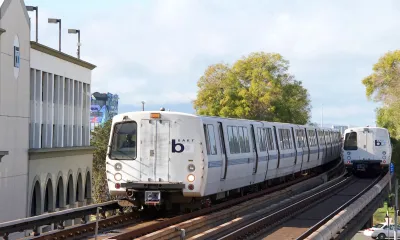 White BART trains passing each other on elevated track in Fruitvale, California.
