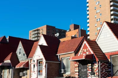 Row of old brick homes in Flushing, Queens, New York with high-rise buildings in background.
