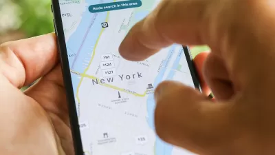 Close-up of hand using smartphone to search New York City map on Airbnb app.
