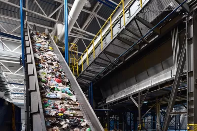 Conveyor belt in industrial recycling center with plastic materials.