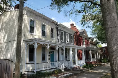 Historic homes with intricate white trim on tree-lined street in Richmond, Virginia.