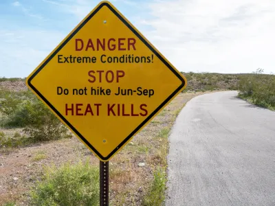 Yellow roadside sign with extreme heat warning: "Danger - Extreme Conditions! - STOP - Do not hike Jun-Sep - HEAT KILLS"