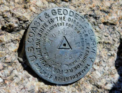 Metal U.S. Geodetic Survey marker in stone in Arizona.