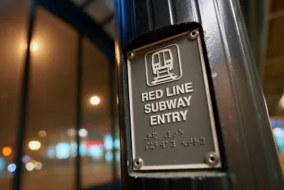 Close-up of 'Red Line Subway Entry' sign with Braille below and train logo above text in Chicago, Illinois.