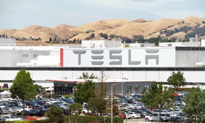 Tesla factory in Fremont, California with dry hills in background.