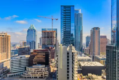 Downtown Austin, Texas skyline with cranes on a sunny day.