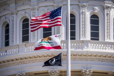 Close-up of U.S., California, and POW-MIA flags on California state capitol dome.