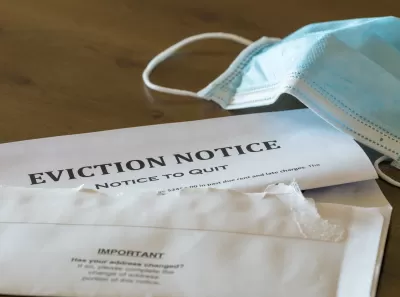 Eviction notice on table with surgical face mask lying next to it.