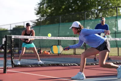 Four people playing pickleball on outdoor court