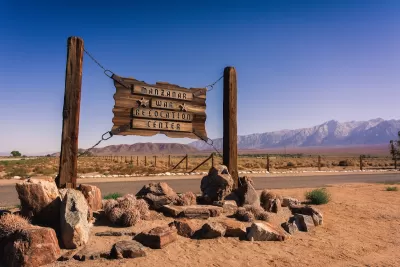 Sign for Manzanar War Relocation Center WWI-era internment camp in California with Sierra Nevada mountains in background.
