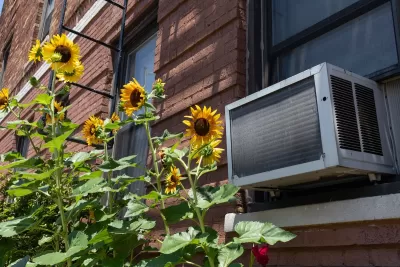 air conditioner unit on brick building wiht sunflowers.