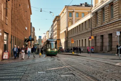 Street scene in Helsinki, Finland with people and streetcars.