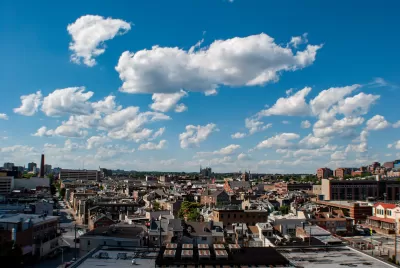 View of east Baltimore, Maryland low-slung brick buildings against a lightly cloudy blue sky