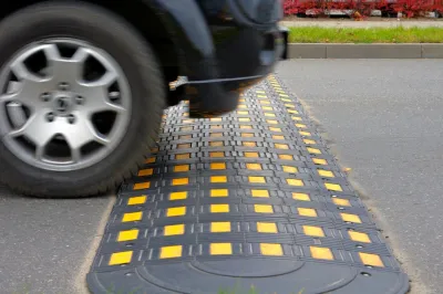 Black and yellow speed hump on road.