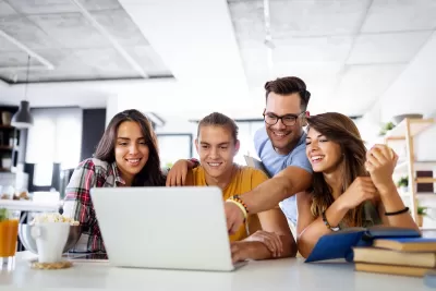 Group of young people enjoying group study at table.