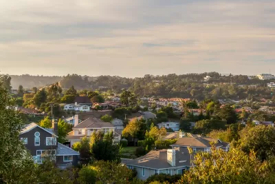 Aerial view of houses against partly cloudy sky in San Mateon County, California.