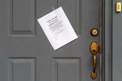 Eviction notice on white paper taped to grey door