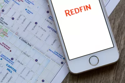 IPhone with Redfin app open, sitting on top of tablet with Google Maps of Portland on the screen.