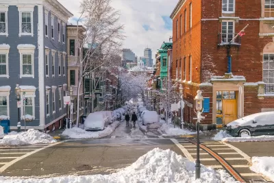 Snowy street scene with old residential buildings in Boston, Massachusetts.