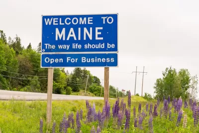 Blue "Welcome to Maine" road sign.