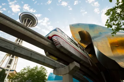 View from under track of Seattle monorail passing under Frank Gehry-designed Museum of Pop Culture with Space Needle in background