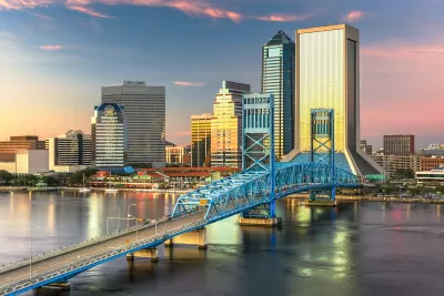 Aerial view of downtown Jacksonville, Florida skyline with bridge in foregorund at dusk.