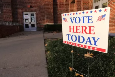 "Vote Here Today" yard sign in front of brick building.