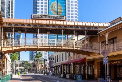 Commercial street in Orlando, Florida with elevated pedestrian walkway crossing the street at Church Street Station historic train station and commercial hub.