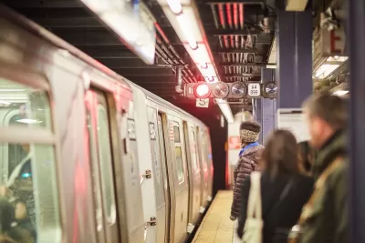 People waiting to board subway train on platform in New York City.