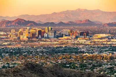Skyline of Phoenix, Arizona with mountains in background at dawn or dusk.