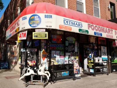 Corner convenience store with red awning and children's rocking horse toy out front in brick building in Queens, New York City