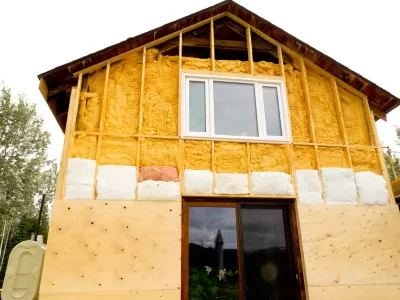 Two-story home being retrofitted with energy-saving insulation.