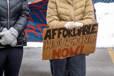 Close-up on protester holding Affordable Housing Now sign.