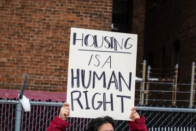Close-up on handmade sign being held up at protest "Housing is a human right"