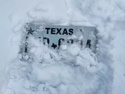 Texas license plate almost entirely covered by snow