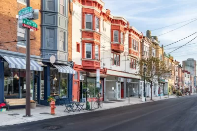Row of three-story buildings with stores and restaurants with awnings on ground floor in Philadelphia, Pennsylvania.