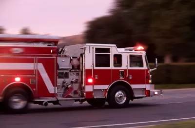 Red fire truck speeding down a street.