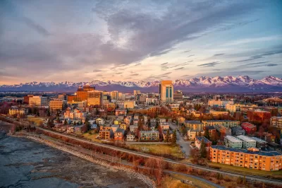 Aerial view of Anchorage, Alaska downtown with mountains in background at golden hour.