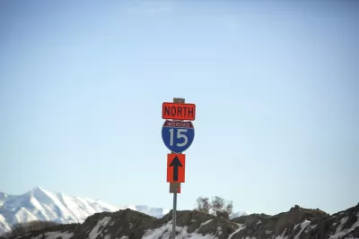 Blue and white Interstate 15 North sign against backdrop of blue sky and snow-capped mountains in Utah