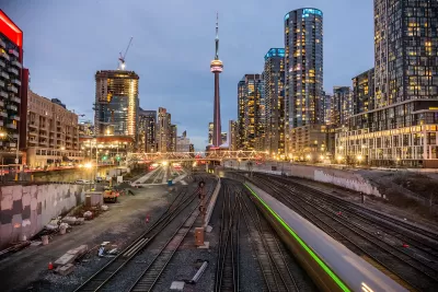 Looking down train trains in downtown Toronto, Canada with CN Tower in background.
