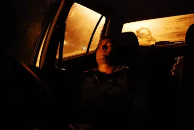 Person sleeping in car at night.