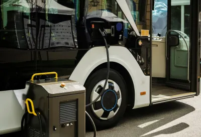 Close-up of electric bus being charged with portable charger.