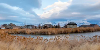 Homes in Saratoga Springs, Utah with pond in foreground.