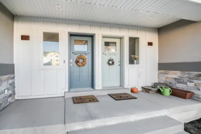 Two pastel green/blue front doors on duplex with decorative wreaths.
