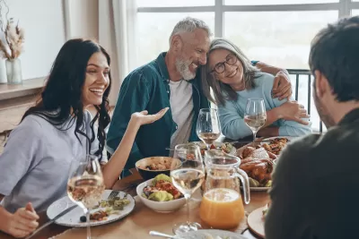 Multi-generational white family sits around dining table